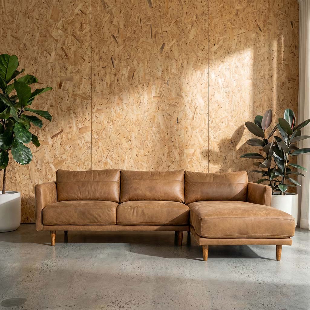 A right side facing chaise lounge sofa upholstered in light brown leather with wooden legs.
